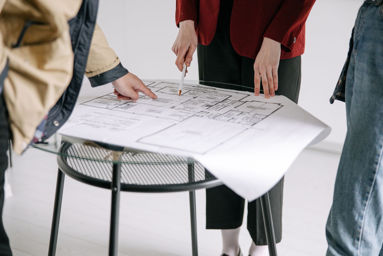 Overleg over een plattegrond, met handen die details aanwijzen